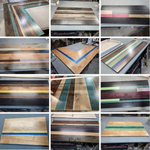 May include: A collection of rectangular wooden tabletops featuring various patterns of multi-colored planks. The surfaces display a mix of natural wood tones, stained finishes, and vibrant painted stripes in blue, green, yellow, and red hues.