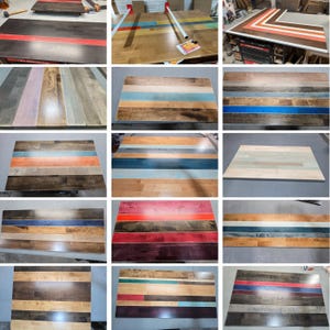 May include: A collection of rectangular wooden tabletops featuring various striped patterns in diverse color combinations including red, blue, orange, and natural wood tones. Each tabletop is constructed from multiple planks joined together.