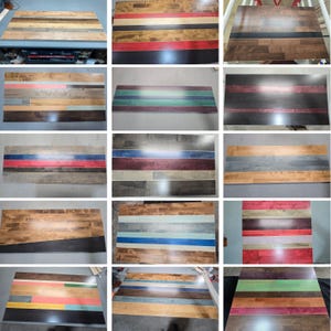 May include: A collection of rectangular wooden boards featuring various horizontal striped patterns in diverse color combinations including red, blue, green, black, and natural wood tones, showcasing smooth finishes and distinct wood grain textures.