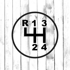 Può includere: Grafica in bianco e nero del modello del cambio di marcia di un'auto. Il disegno, all'interno di una cornice circolare, mostra le lettere e i numeri R, 1, 2, 3 e 4. Lo sfondo è una superficie di assi di legno bianche.