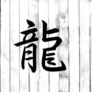 Può includere: Calligrafia a inchiostro nero su sfondo di legno bianco. La parola "龍" è scritta in caratteri giapponesi kanji, che significa "drago".