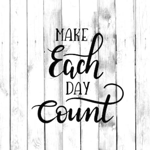 以下が含まれることがあります： 白い木製の背景に黒い筆記体で「MAKE Each DAY Count」と書かれています。言葉は流れるようなエレガントなフォントです。背景は、垂直で風化した木板で構成されています。