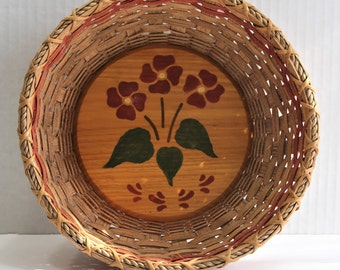 Cesta redonda con base de madera. Diseño floral pintado a mano. Diseño rosa (tinte rojo descolorido) y canasta en tono natural. Excelente estado vintage.
