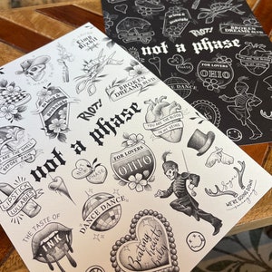 Può includere: Foglio di flash di tatuaggio in bianco e nero con vari disegni tra cui cuori, labbra, un teschio, un microfono, una palla da discoteca e una figura scheletrica. Il foglio ha il testo "RIOT! not a phase" in grassetto, lettere nere.