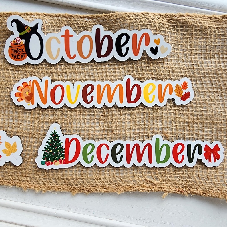 Puede incluir: Tres letreros rectangulares blancos con ilustraciones coloridas de tem&aacute;tica oto&ntilde;al y las palabras "Octubre", "Noviembre" y "Diciembre".