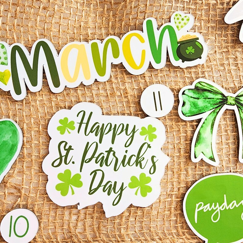May include: A set of St. Patrick's Day themed party decorations with green shamrocks, a green bow, and the words "March" and "Happy St. Patrick's Day".