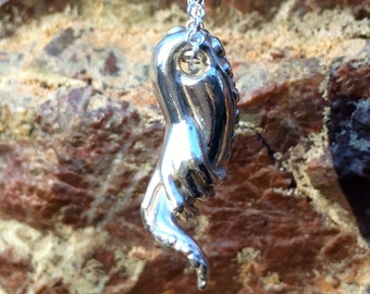 Hand grasping a tentacle, sterling silver pendant