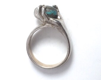 Blue Turquoise Ring, Silver Hand holding a Round Cut Tourquoise Stone