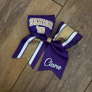 Senior 2026, monogrammed purple, old gold and white glitter cheer bow