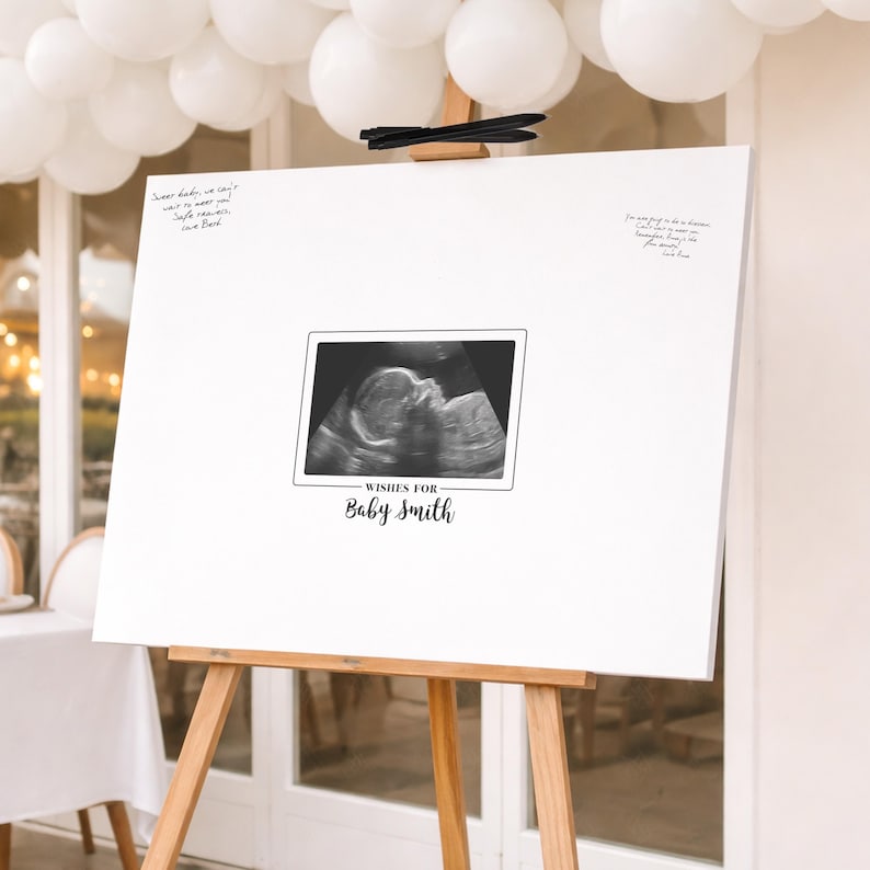 A sonogram baby shower guest book canvas. The white background has handwritten messages and a sonogram image. The text "Wishes for Baby Smith" is below the sonogram. A pen is left for guests to write messages.