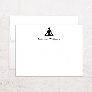 May include: White stationery set featuring a black silhouette of a person in a seated yoga pose. The name "Madison Whitman" is printed in black below the image. The set includes a folded card and an envelope.