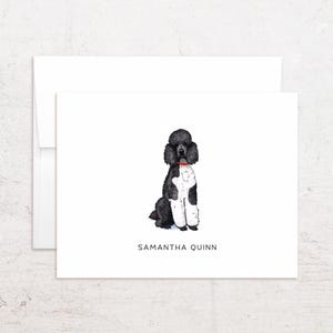 May include: A white card with a black and white poodle illustration wearing a red collar. The card has the name "SAMANTHA QUINN" printed in black at the bottom. A white envelope is behind the card.