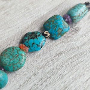 Peut inclure: Un collier de perles turquoise et brun avec des perles carr&eacute;es et rondes. Les perles ont un motif marbr&eacute;.