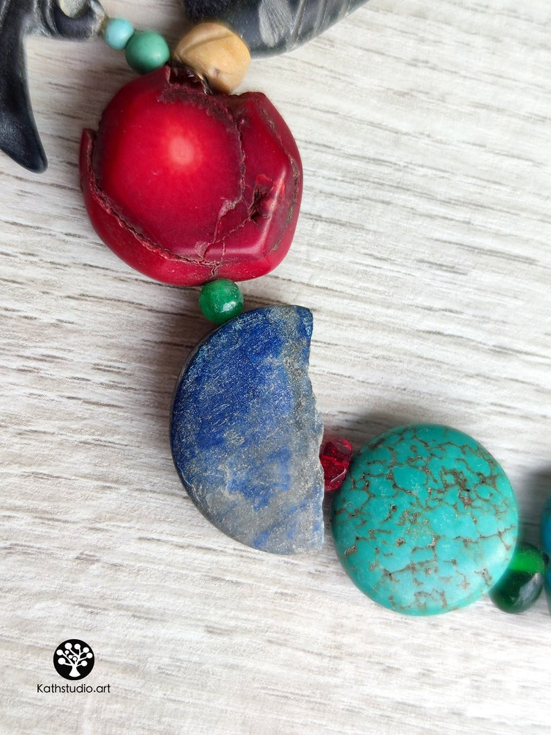 Peut inclure: Gros plan sur un collier avec des perles rouges, bleues, vertes et turquoise. Les perles sont faites de diff&eacute;rents mat&eacute;riaux, dont le corail, le lapis-lazuli et la turquoise.