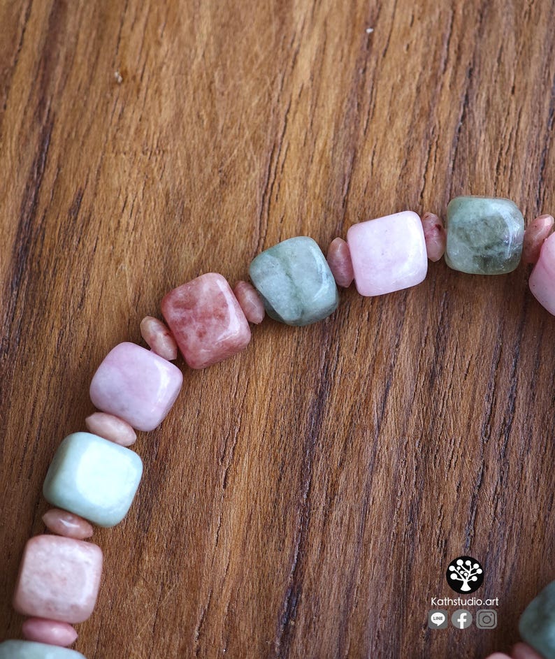 May include: A beaded bracelet featuring alternating square-shaped beads in shades of pale pink, dusty rose, and sage green, separated by small, rounded, light pink spacer beads. The text Kathstudio.art is printed in the bottom right corner.