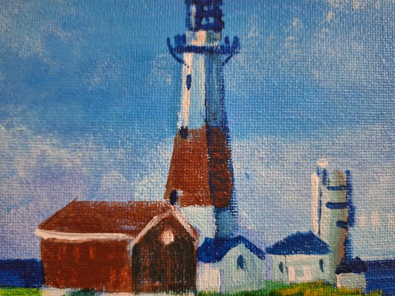 May include: A painting of a lighthouse with a red brick base and a white and blue tower. The lighthouse is surrounded by smaller buildings with white and blue paint. The sky is a light blue with white clouds.