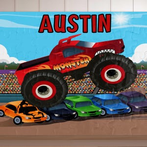 May include: A personalized puzzle featuring a red monster truck with the word "MONSTER" in yellow flames. The name "AUSTIN" is displayed in red. The puzzle includes colorful cars and a crowd.