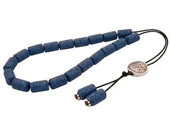 May include: A blue lava stone prayer bead mala with a silver charm featuring a star design. The mala has a tassel made of two lava stone beads.