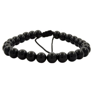 Peut inclure: Un bracelet noir en perles avec une fermeture en cordon noir.