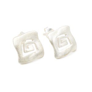 May include: A pair of silver earrings with a square shape and a geometric design. The earrings have a brushed finish.