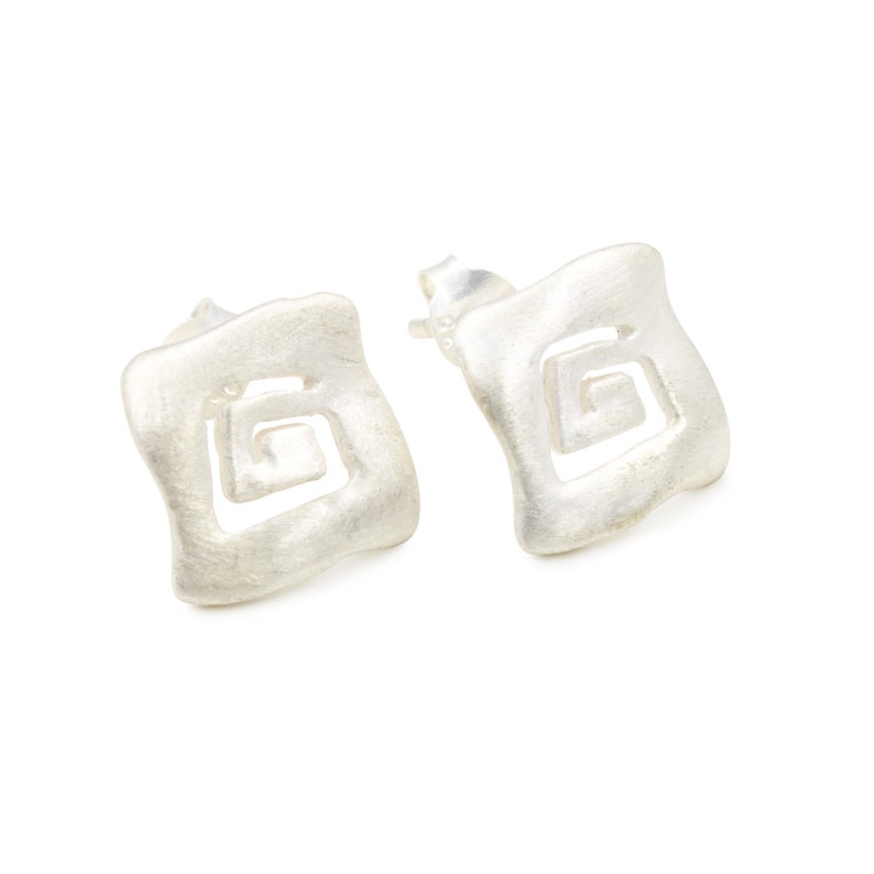 May include: A pair of silver earrings with a square shape and a geometric design. The earrings have a brushed finish.