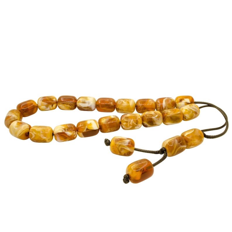 May include: A brown and white prayer beads necklace with a brown tassel. The beads are made of a marbled material.