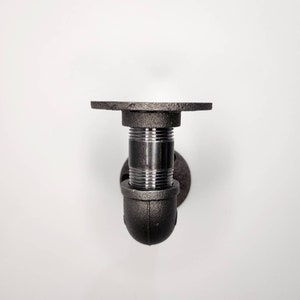 Puede incluir: Soporte de estante de tuber&iacute;a de metal negro con base redonda y parte superior plana. El soporte est&aacute; dise&ntilde;ado para montarse en una pared.