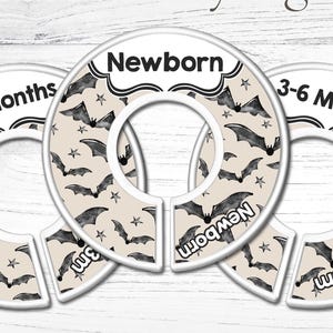 May include: Three circular nursery organizers with bat and star patterns. The organizers are labeled "Newborn", "0-3 Months", and "3-6 Months". The words "Handmade Nursery Organizers" are at the top.