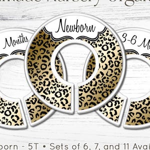 May include: Circular nursery organizers with a gold and black leopard print design. The organizers are labeled "Newborn", "0-3 Months", and "3-6 Months". The text "Handmade Nursery Organizers" is at the top. The website www.carriedeehc.etsy.com is at the bottom.