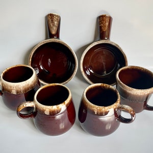 Puede incluir: Conjunto de seis tazas y cuencos de cerámica esmaltada marrón y blanca. Las tazas tienen asas y los cuencos tienen un solo asa en un lado.