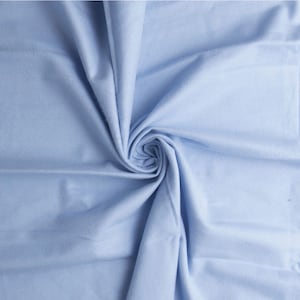 May include: A light blue fabric swatch with a soft, smooth texture. The fabric is folded and draped, showcasing its drape and flow.