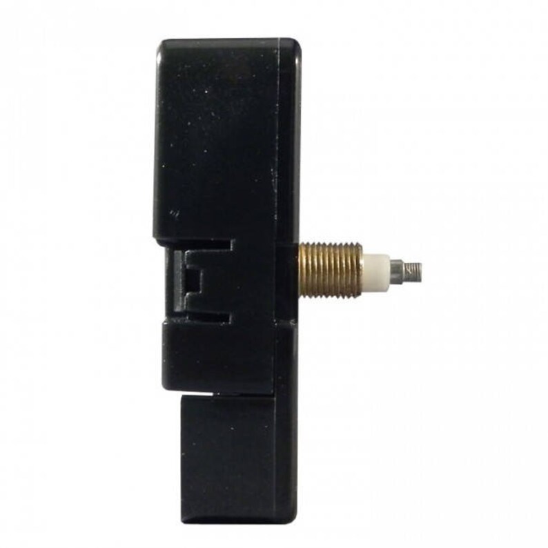 May include: A black clock movement with a gold-colored winding stem and a white plastic washer.