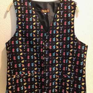 May include: A black sleeveless vest with a colorful pattern of dancing bears and hearts. The vest has a label that says "The Museum" on it.