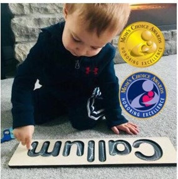 A chalkboard-finish wooden name puzzle that doubles as a keepsake — the blackboard aesthetic makes it stand out from the sea of plain birch puzzles.
