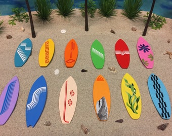 May include: A collection of twelve miniature surfboard ornaments in various colors including blue, yellow, orange, green, red, pink, purple, and cream. Each surfboard features unique graphic designs such as stripes, flowers, waves, and a shark.