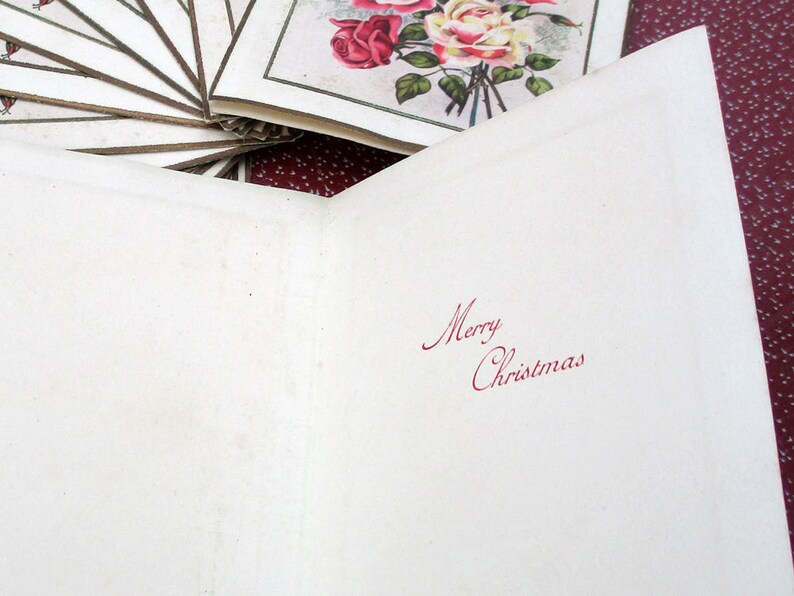 May include: A blank white card with the words "Merry Christmas" written in red ink. The card is folded in half and has a white background.