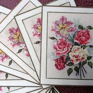 May include: A set of vintage cards with a floral design. The cards feature a bouquet of pink and white roses and lilies with green leaves on a white background.