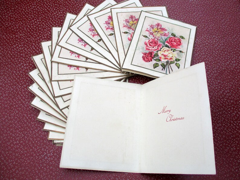 May include: A stack of vintage Christmas cards with a floral design and the words "Merry Christmas" on the front.