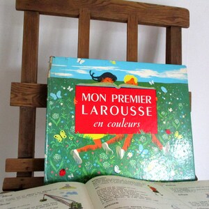 May include: A vintage children's book titled "Mon Premier Larousse en couleurs" with a colorful illustration of two children in a field of flowers.
