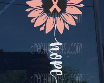 Könnte beinhalten: Rosa Sonnenblume mit einem rosa Band in der Mitte und dem Wort "Hope" in weißer Kursivschrift darunter.