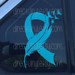 May include: Teal blue ribbon with a feather and flying birds, representing hope and remembrance. The ribbon is a symbol of support for those affected by cancer.