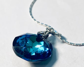 Peut inclure: Un collier en chaîne argent avec un pendentif en cristal bleu.