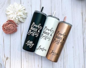 May include: Three tall, cylindrical stainless steel tumblers with lids and straws. One is matte black, one is white, and one is metallic rose gold. Each features the black text "Beaches BOOZE & Besties" and a unique name: Ally, Lauren, or Jessie.