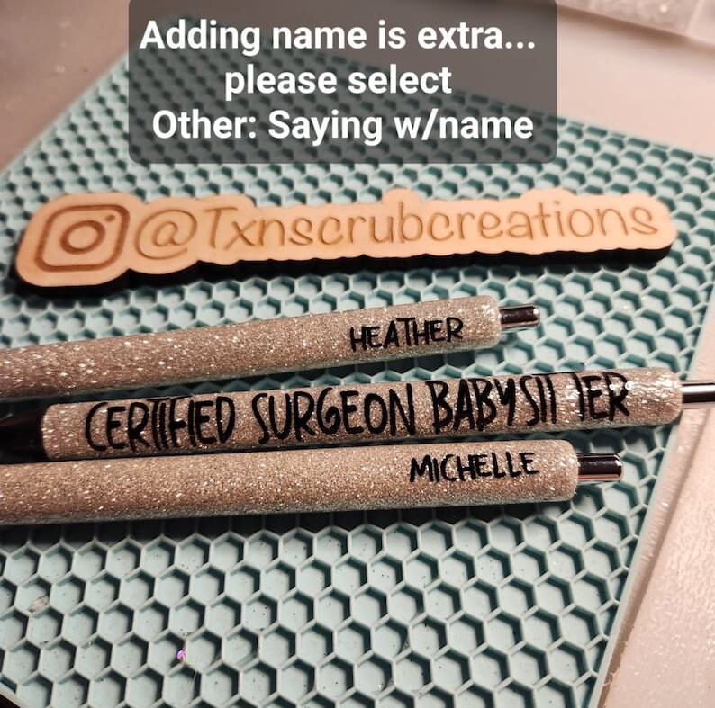 May include: Three silver glitter pens with black lettering. The pens say "HEATHER", "CERTIFIED SURGEON BABYSITTER", and "MICHELLE".