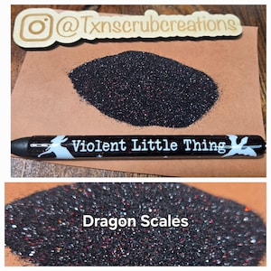 May include: Two samples of black glitter with red and silver flecks. The first sample is labeled "Violent Little Thing" and the second sample is labeled "Dragon Scales".
