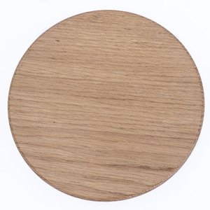 Puede incluir: Un posavasos redondo de madera con un acabado de grano de madera natural.