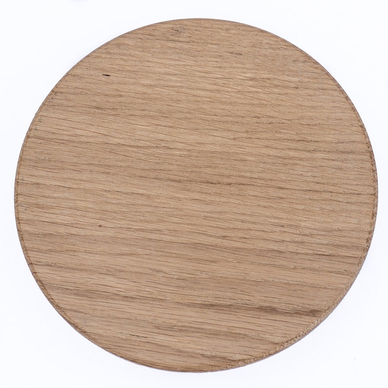 Puede incluir: Un posavasos redondo de madera con un acabado de grano de madera natural.