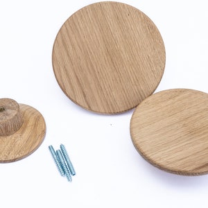 Puede incluir: Tres ganchos de pared circulares de madera de roble natural. Los ganchos tienen un acabado liso y pulido y se fijan a la pared con tornillos.