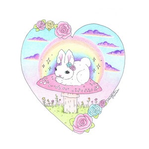 以下が含まれることがあります： 白い花冠をかぶった白いウサギが、白い斑点のあるピンクのキノコに座っています。キノコは緑の草地にあり、花と虹が背景にあります。画像はハート型です。