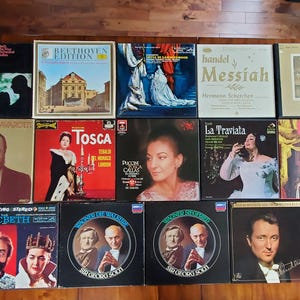 May include: A collection of 12 vintage opera record albums with colorful covers featuring singers, composers, and titles like "Tosca", "La Traviata", and "Messiah".